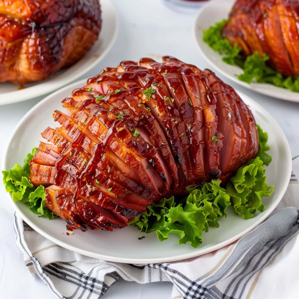 Tender and juicy Coca-Cola Glazed ham served with lettuce in a white plate