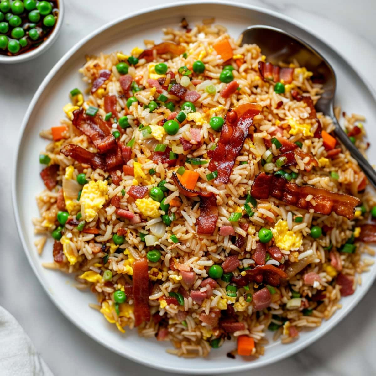 Bacon fried rice served in a white round plate.