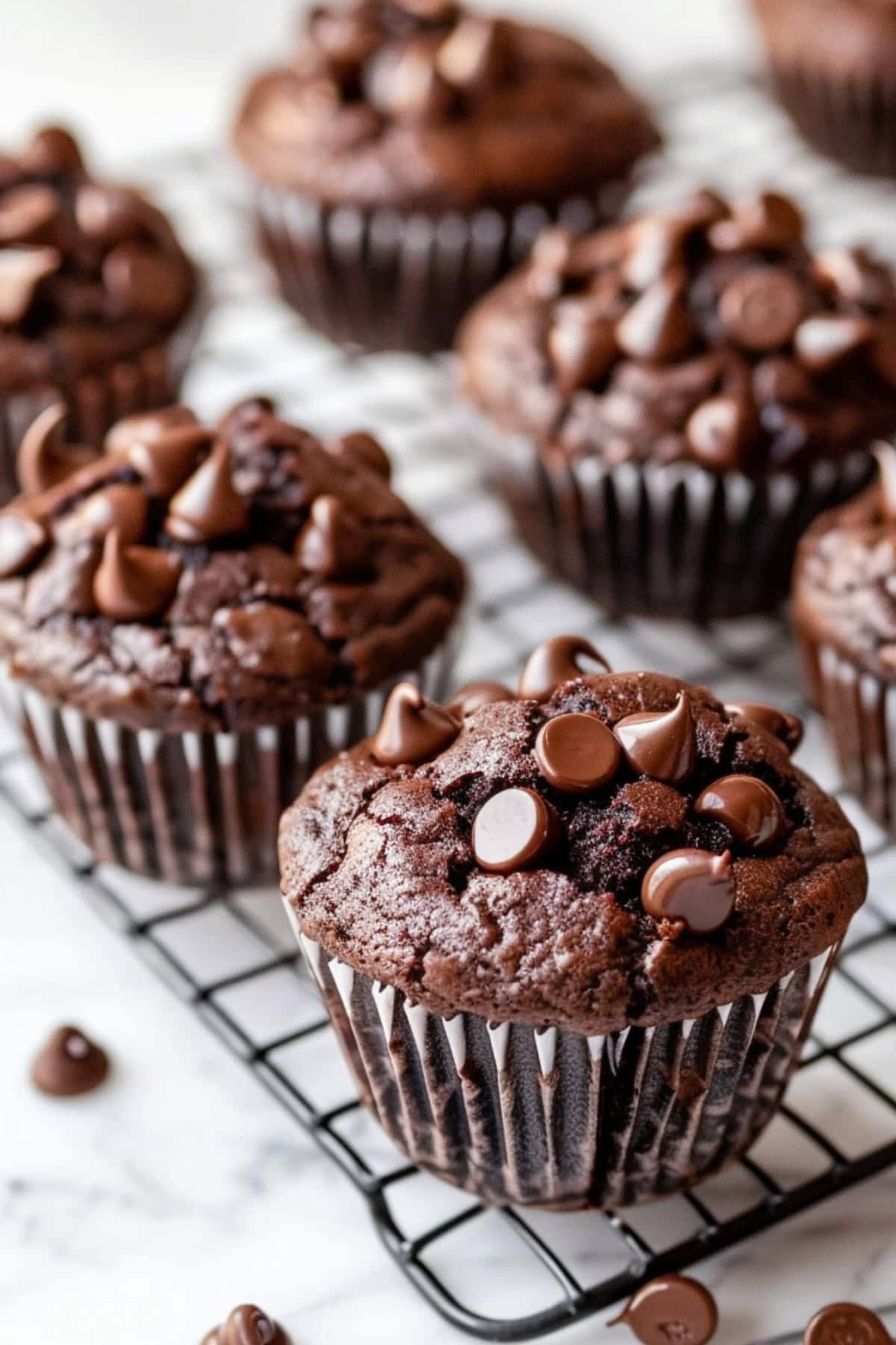 Bunch of triple chocolate muffins arranged in a cooling rack.