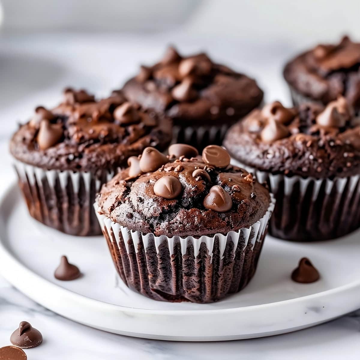 Bunch of triple chocolate muffins arranged in a white plate.