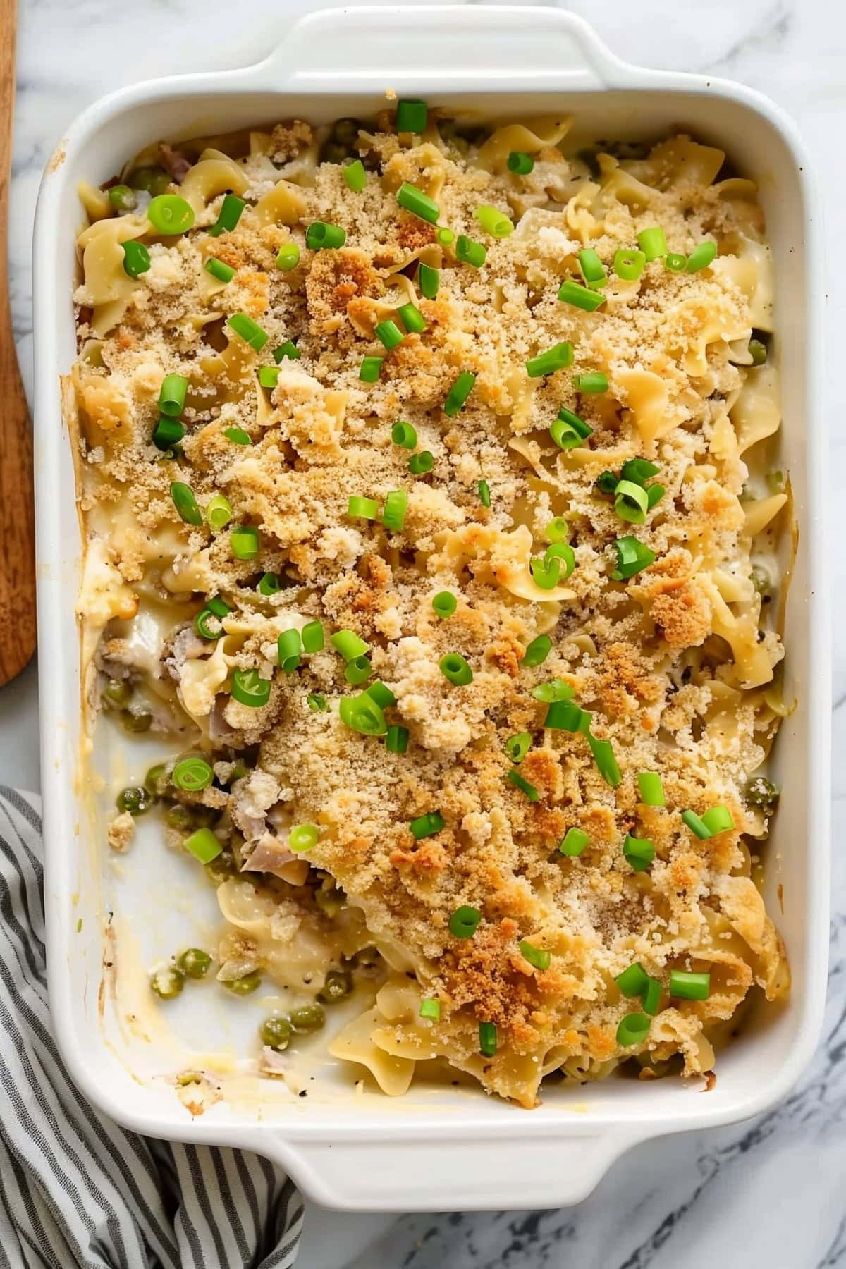 Creamy homemade tuna noodle casserole topped with chopped chives and breadcrumbs.