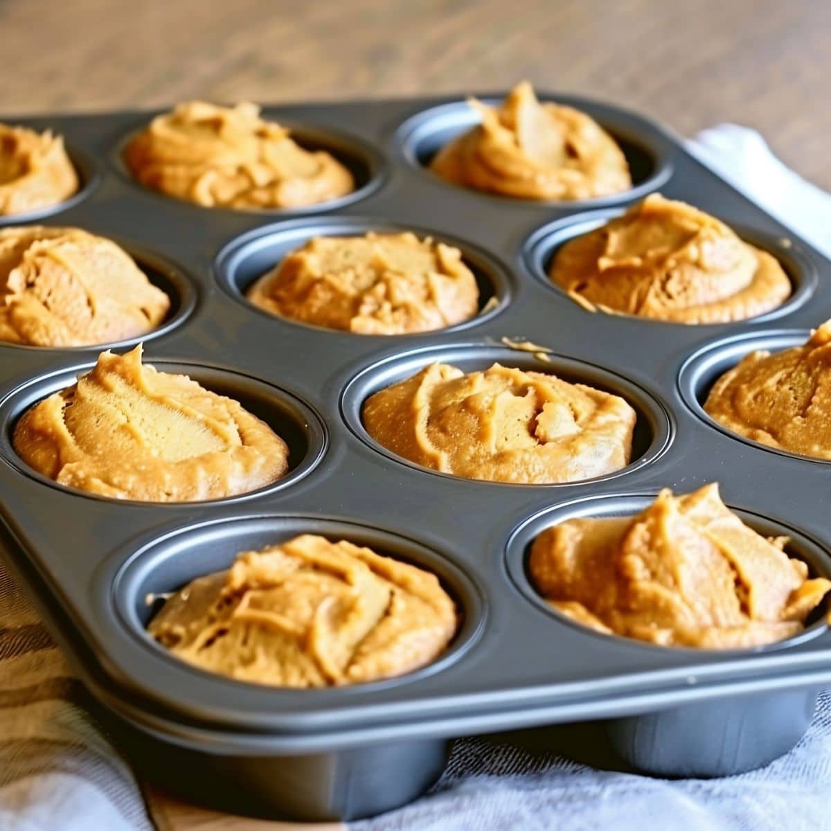 Two-Ingredient Pumpkin Muffin Uncooked Batter in a Muffin Tray, Ready to Go in the Oven