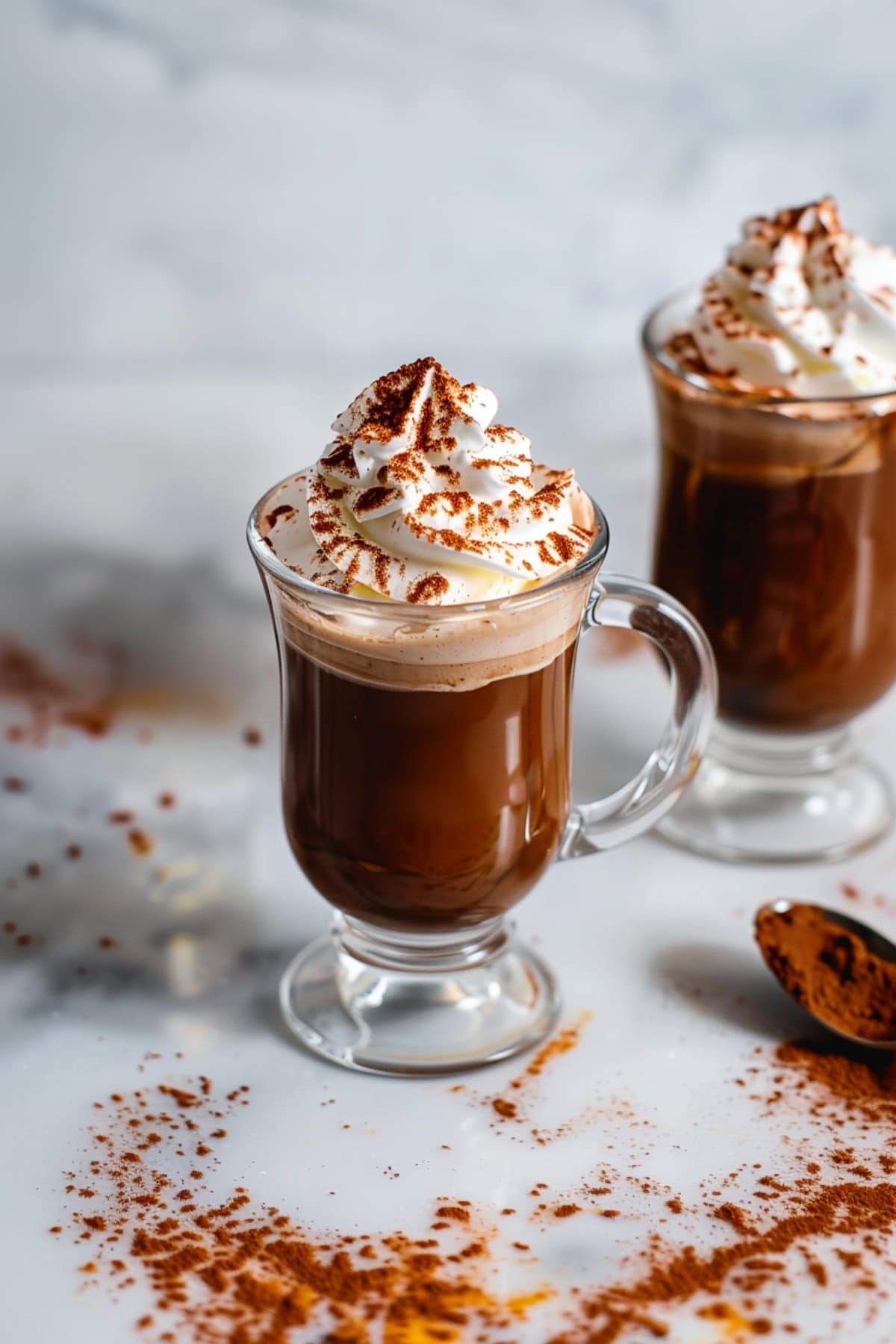 Cozy mugs of Kahlua-infused hot chocolate, topped with whipped cream and and cocoa powder