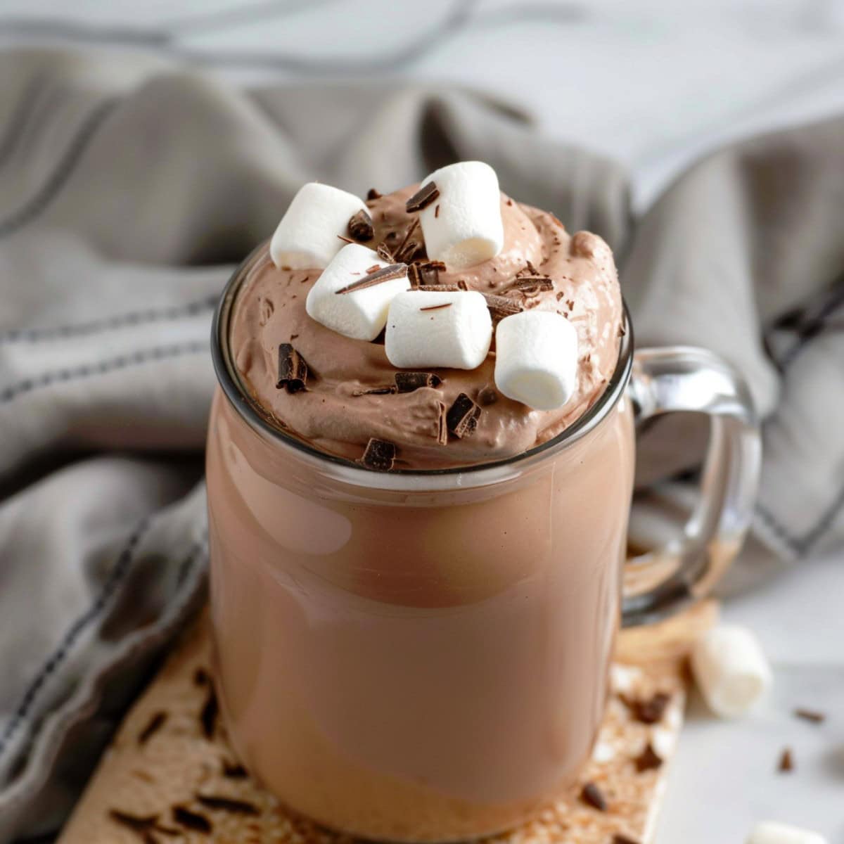 A glass jar of creamy and decadent hot chocolate whipped cream