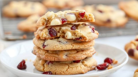 Stack of cranberry with white chocolate cookies in a white plate.