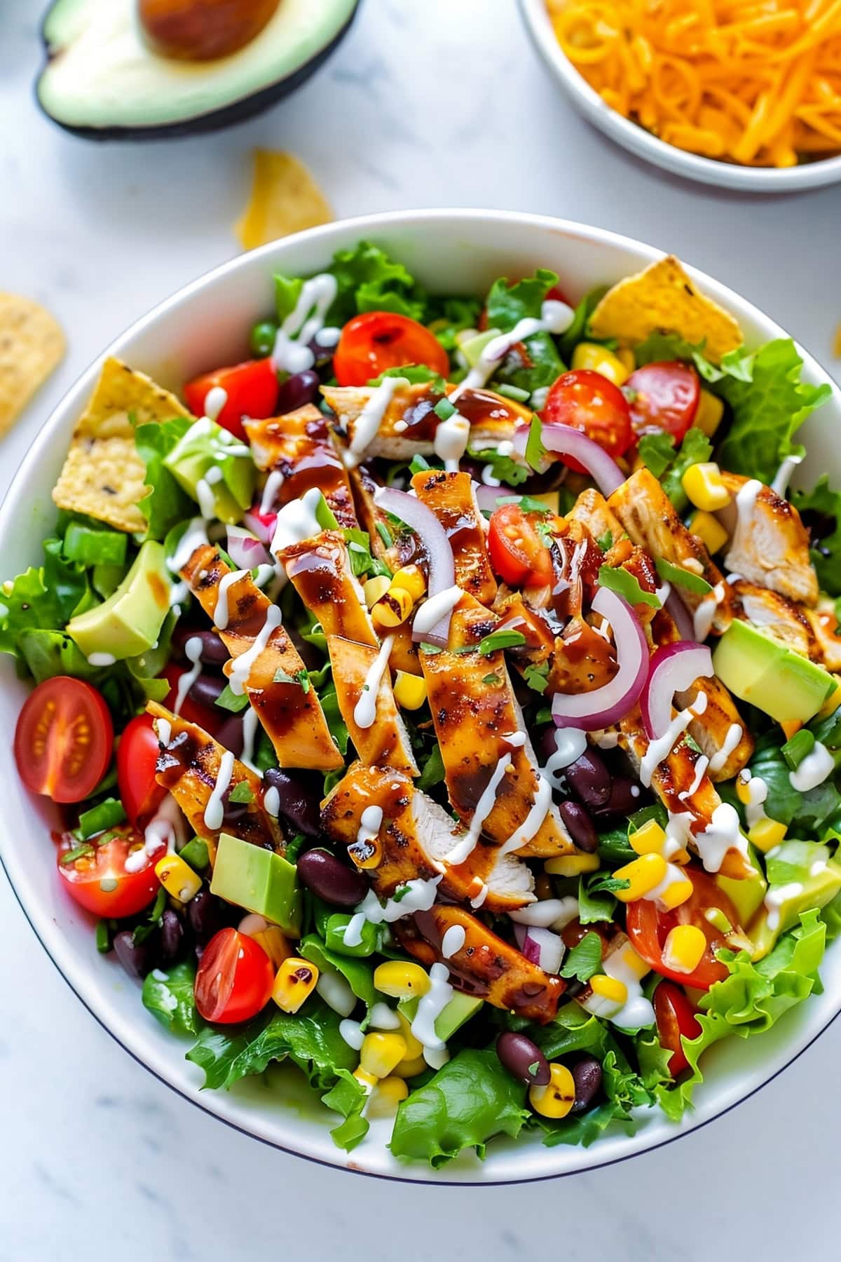 BBQ chicken salad with vibrant ingredients including black beans, corn, and shredded cheddar cheese.