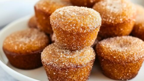 Cinnamon sugar coated apple cider donut muffins in a white plate.