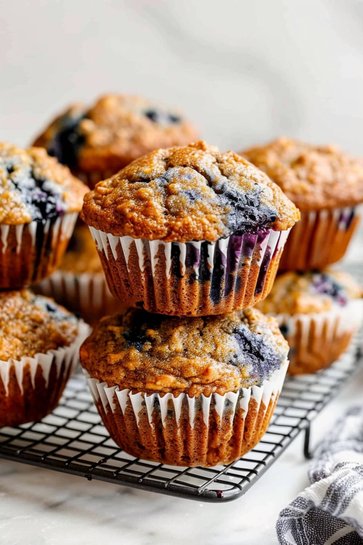 Freshly baked banana blueberry muffins stack on a cooling rack