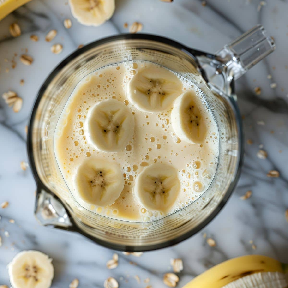 Top View of Banana Daiquiri in a Blender with Slices of Banana