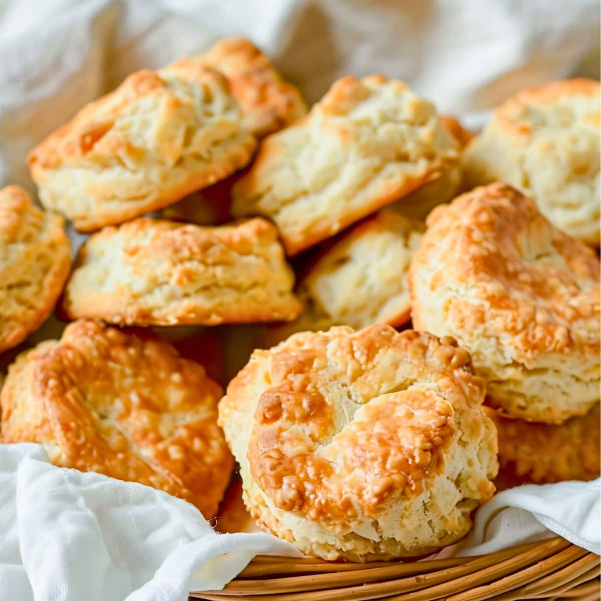 Bisquick Drop Biscuits Piled in a Bread Basket with a Kitchen Towel Beneath Them