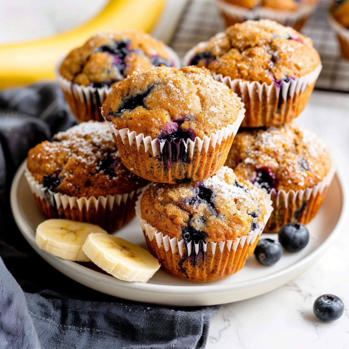 Banana blueberry muffins on a white plate with fresh fruits 
