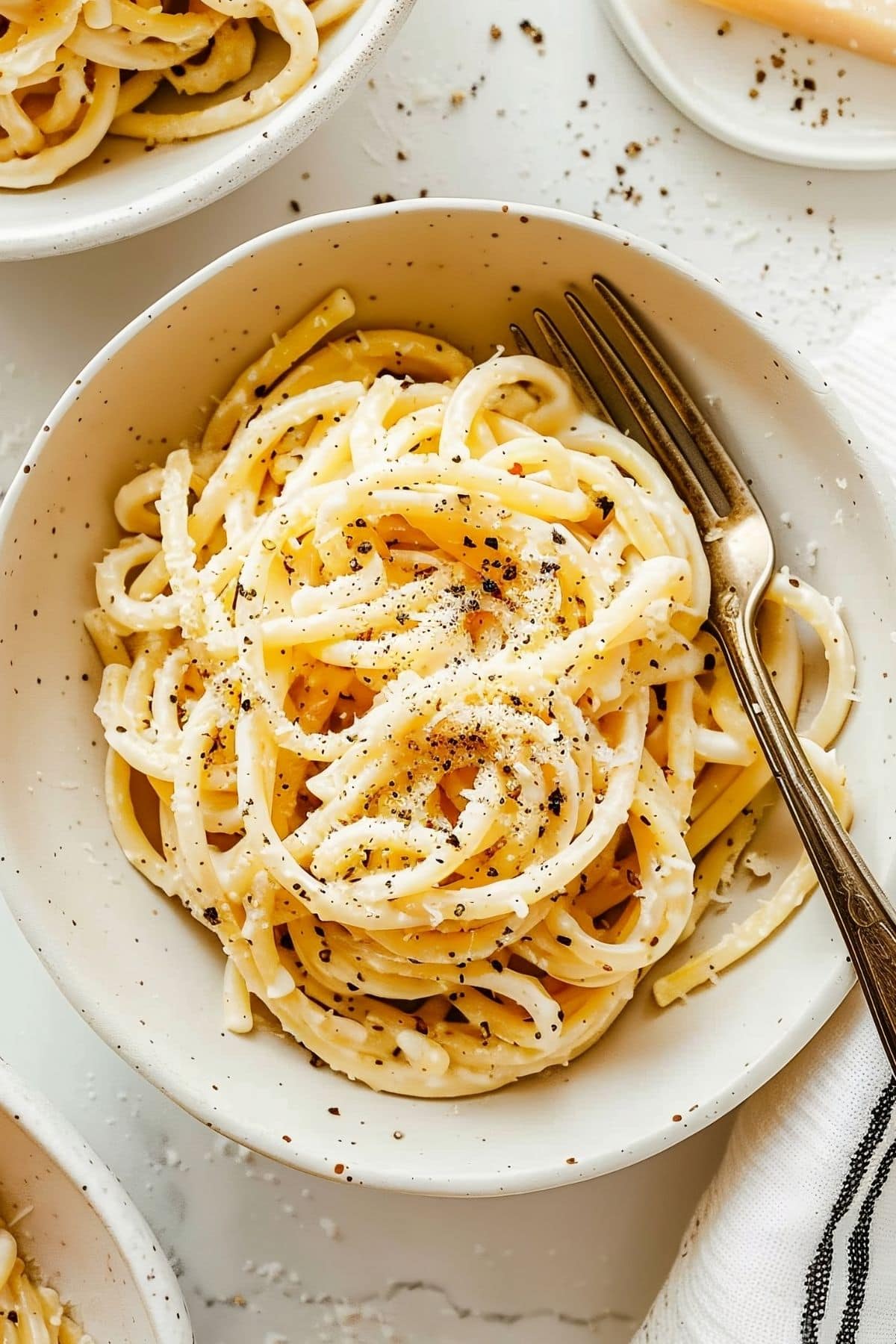 Top View of Three Bowls of Cacio e Pepe with a Fork