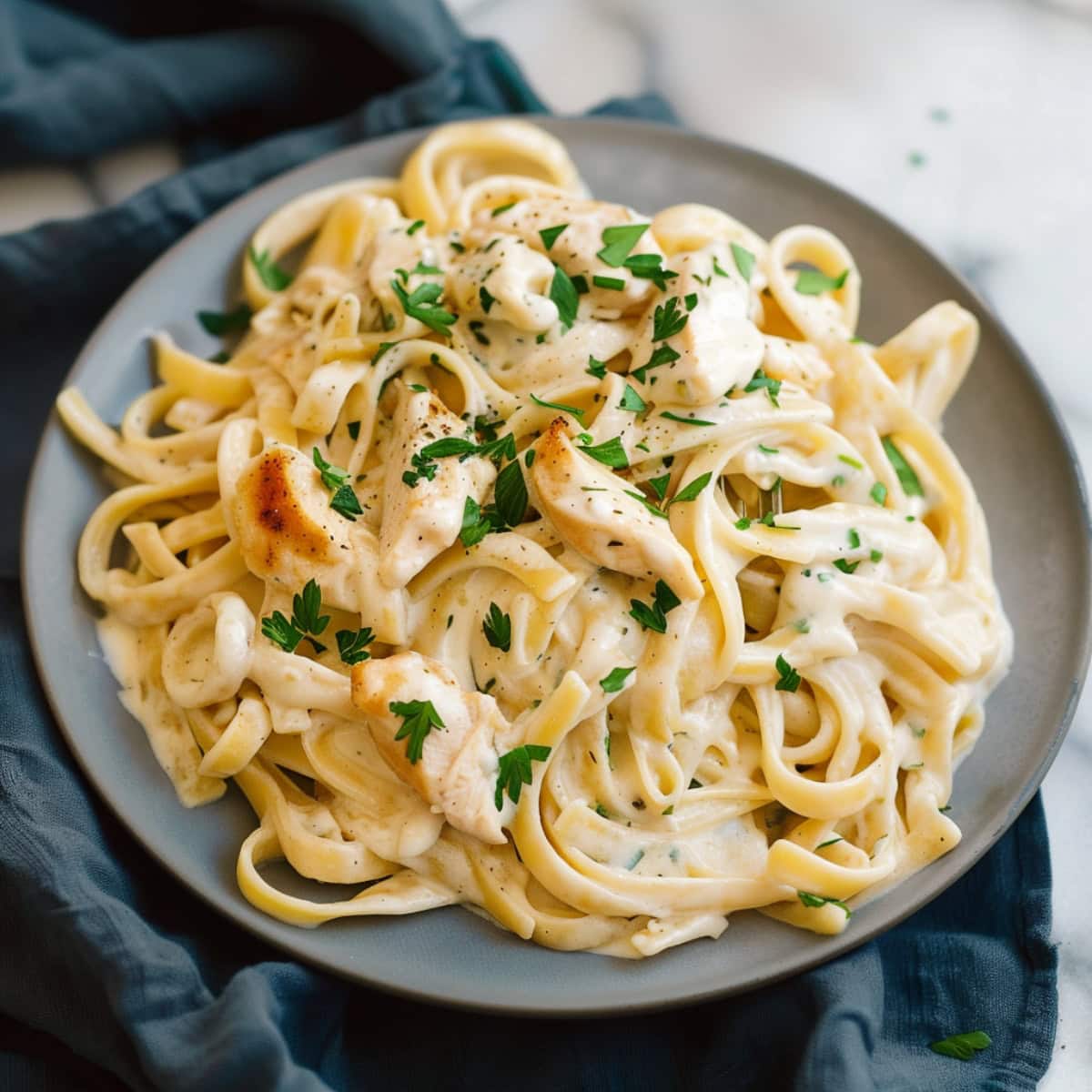Homemade chicken Alfredo, made with a rich, buttery sauce and tender pasta.