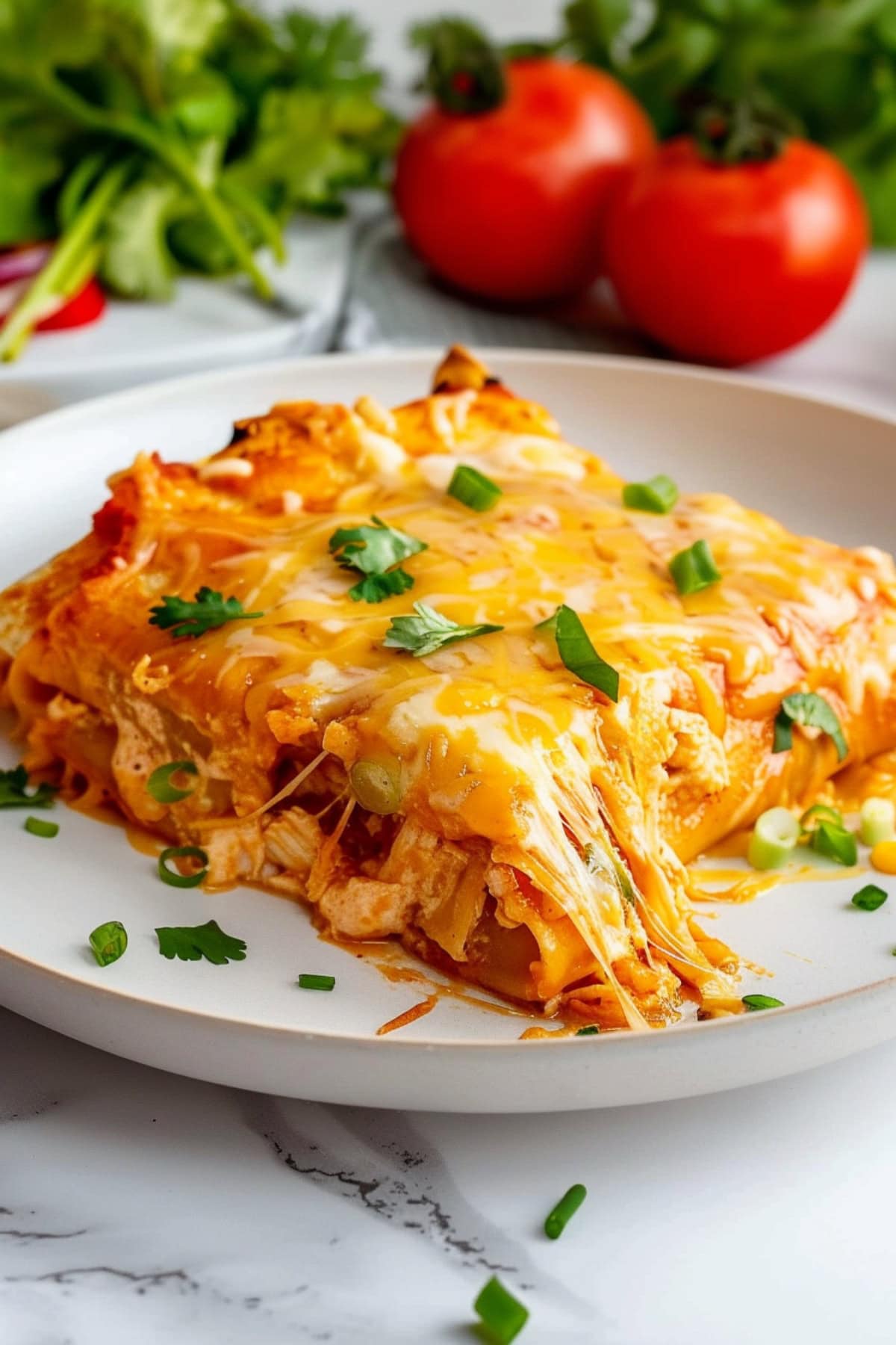 Cheesy chicken enchilada on a plate garnished with parsley.