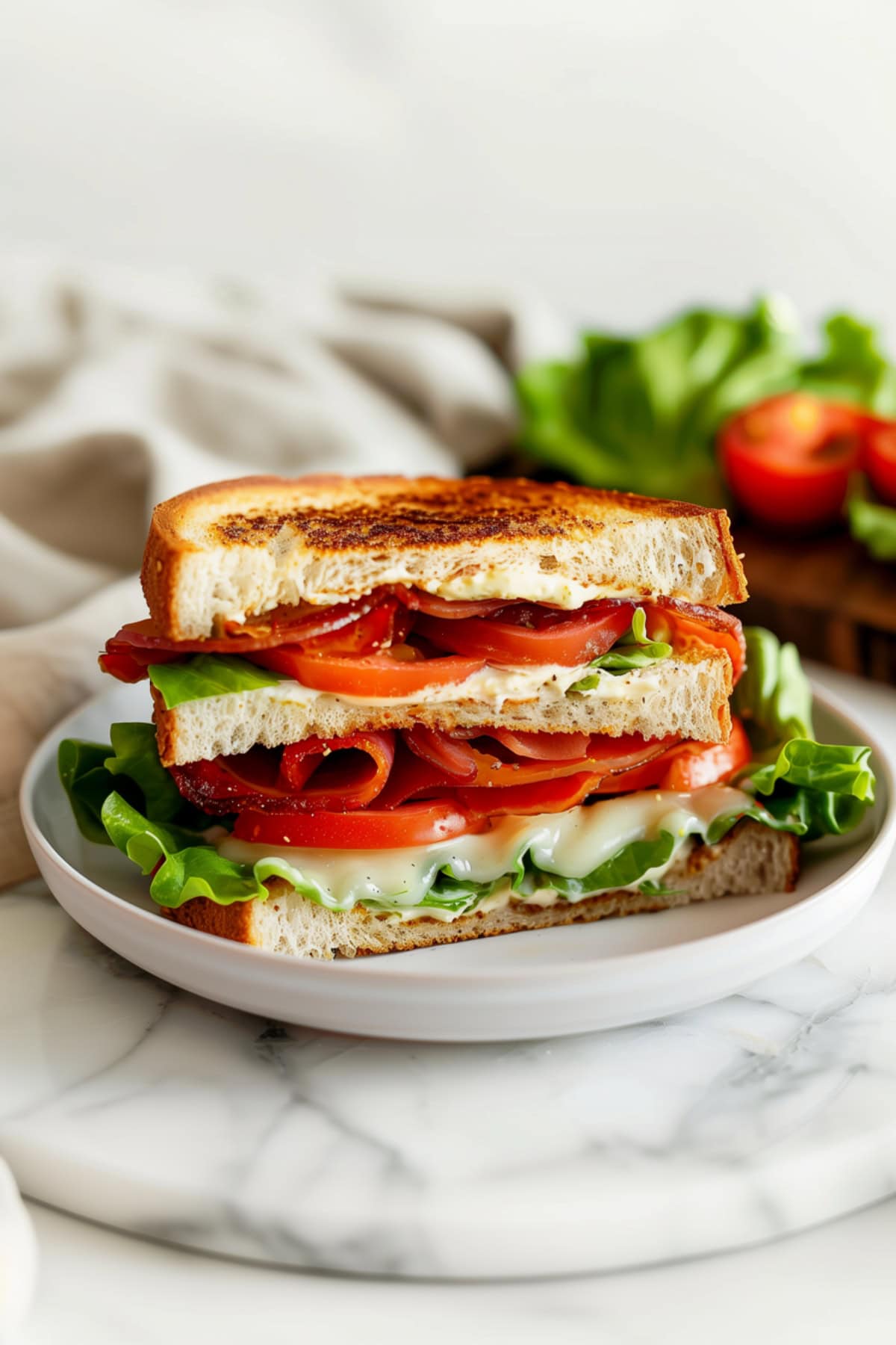 Savory BLT sandwich, served on whole grain bread with a creamy mayo spread.