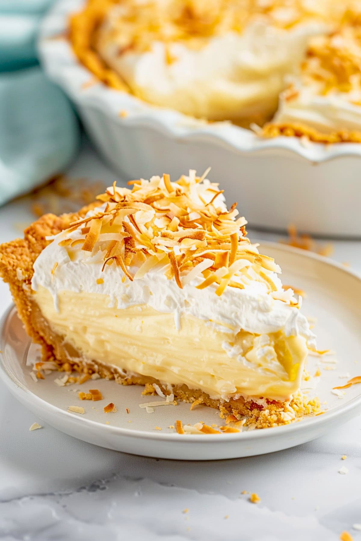 Slice of coconut cream pie in a plate.