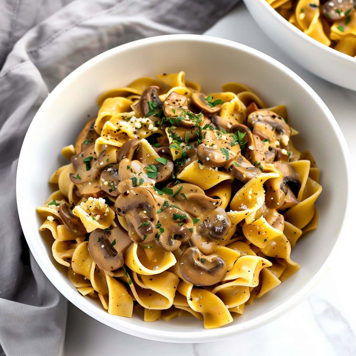 A creamy mushroom stroganoff with a rich sauce, topped with a sprinkle of chopped herbs.