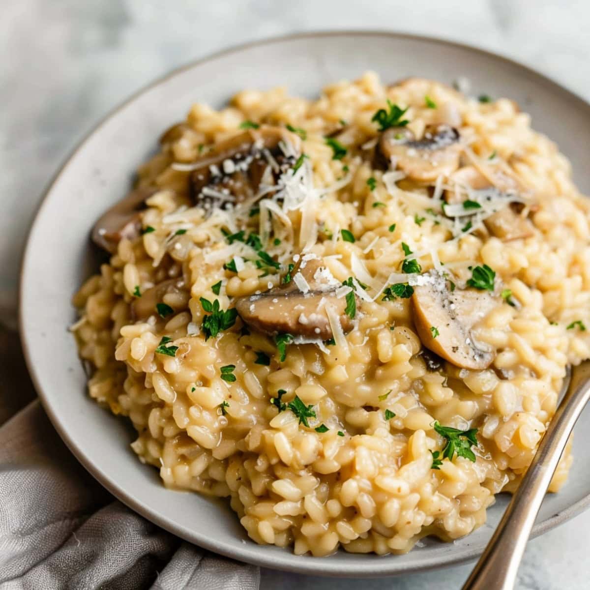 A creamy mushroom risotto, highlighting the tender Arborio rice, garnished with parsley and parmesan.