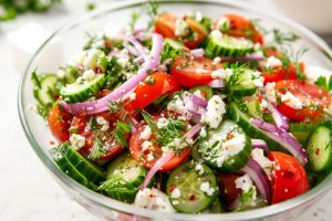 Cucumber tomato feta salad in a large glass bowl.