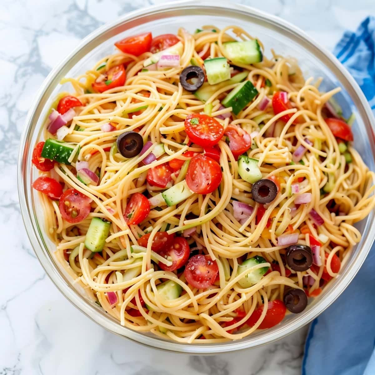 Flavorful homemade California spaghetti salad with red onions, tomatoes and olives.