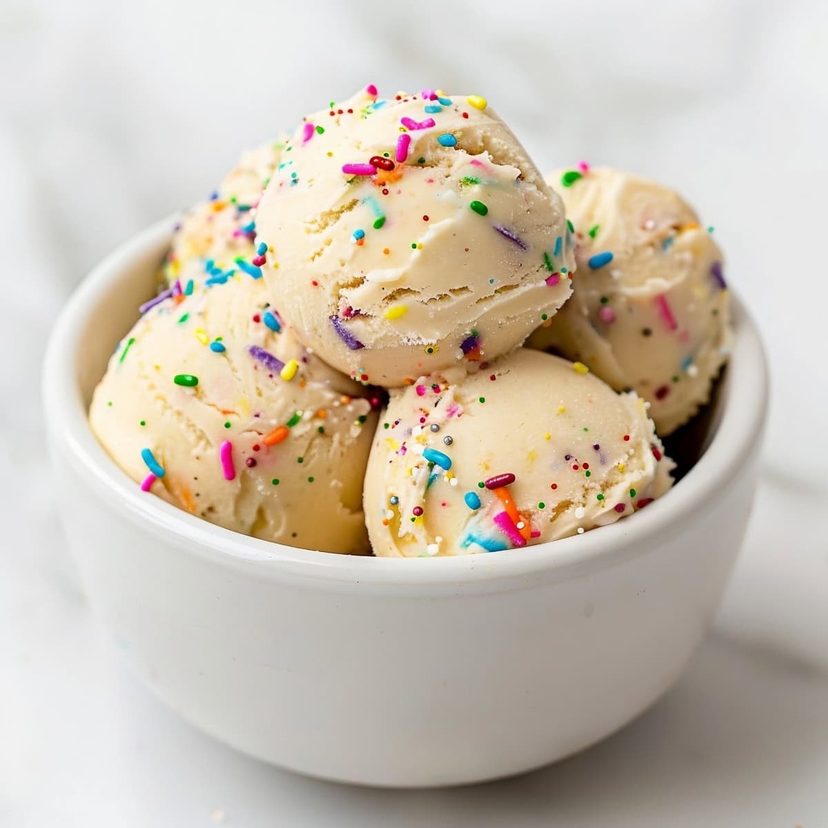 Funfetti homemade scoops of edible cookie dough in a white bowl.