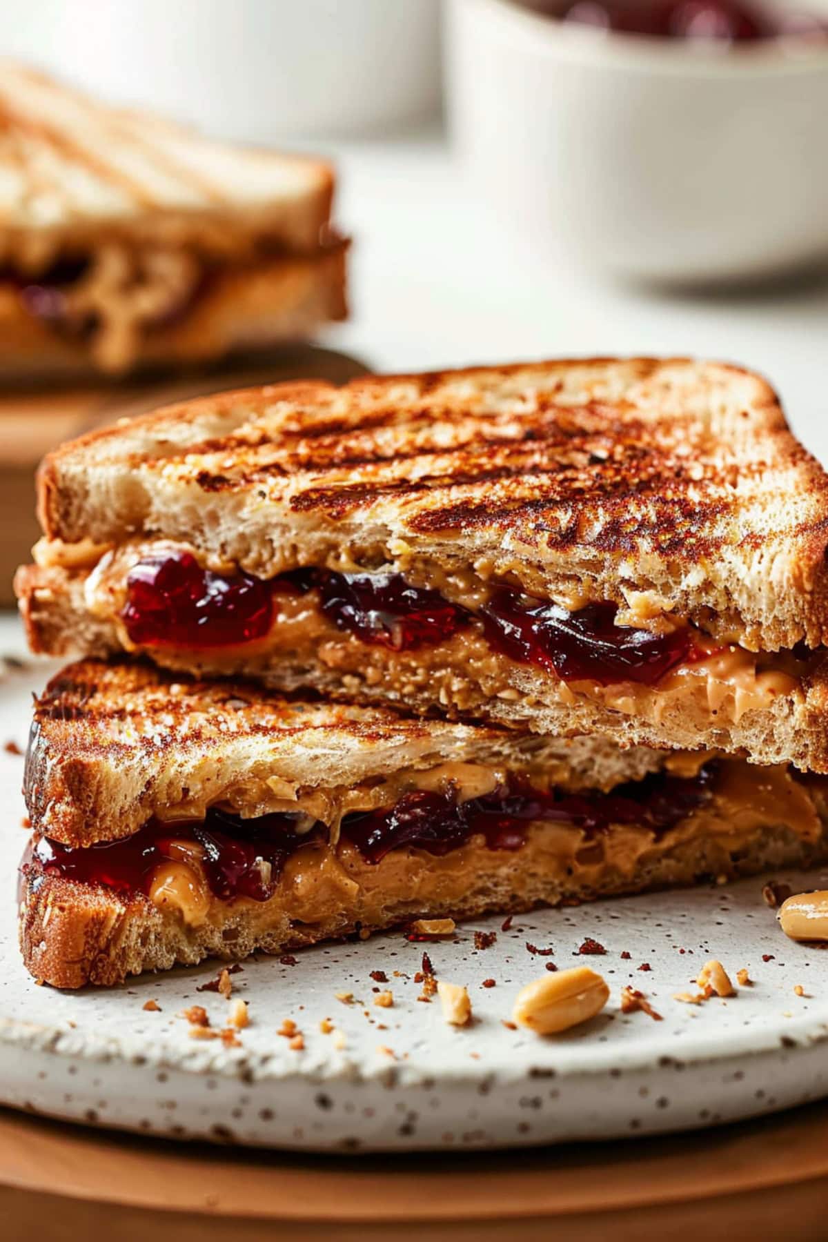 Sandwich with peanut butter and jelly filling in a plate.