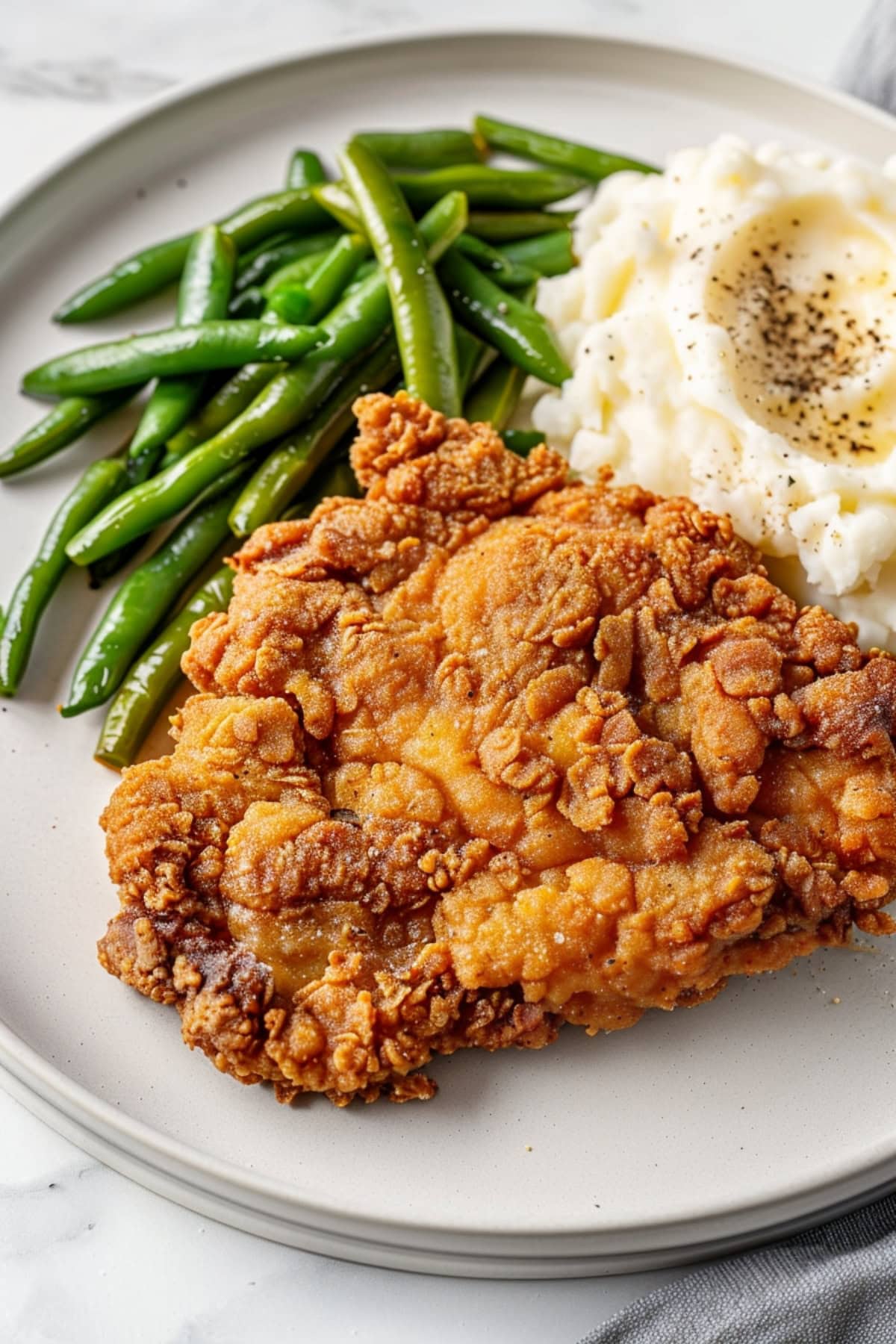 Delicious chicken fried steak with mashed potatoes and green beans