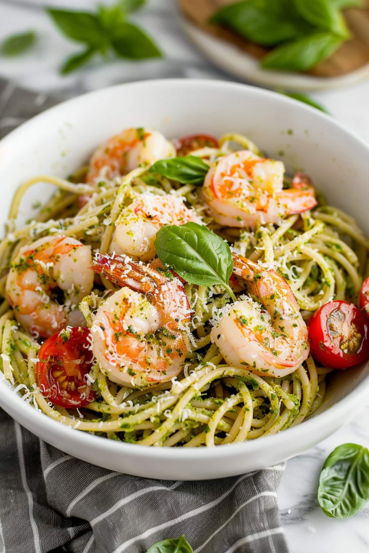 Fresh pesto shrimp pasta with cherry tomatoes and shredded parmesan cheese.