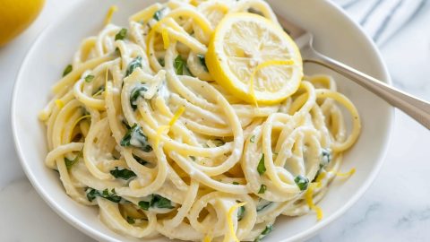 Citrusy and delicious lemon ricotta pasta with fork in a bowl ready to serve.