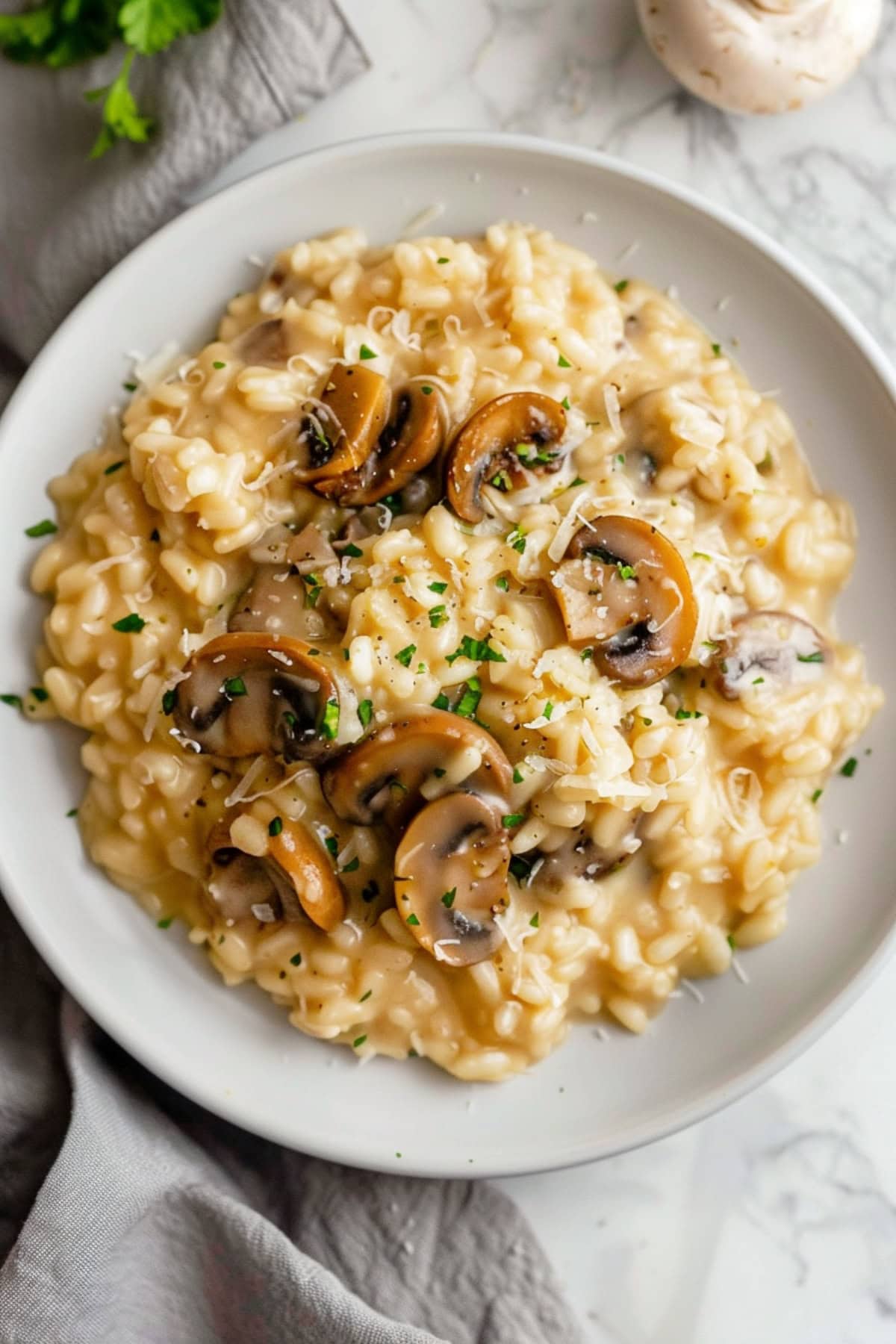 A creamy plate of mushroom risotto garnished with fresh parsley and grated Parmesan cheese.