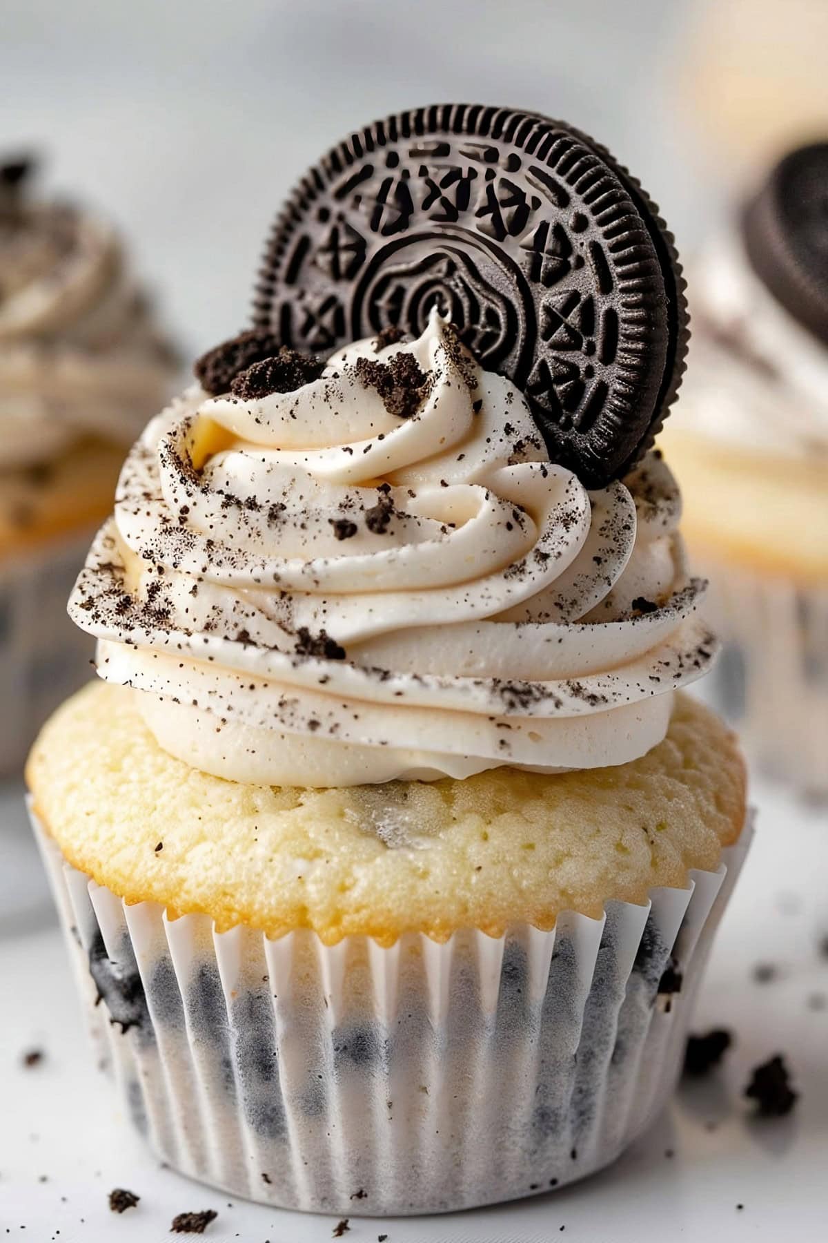 Decadent Oreo cupcake topped with creamy frosting and a cookie biscuit sandwich.