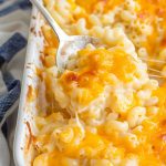 Close Up of Sweetie Pie's Mac and Cheese in a Casserole Dish with a Spoon and a Blue Kitchen Towel