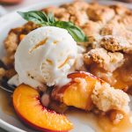 Close Up of Patti Labelle's Peach Cobbler on a Plate with Vanilla Ice Cream and Mint