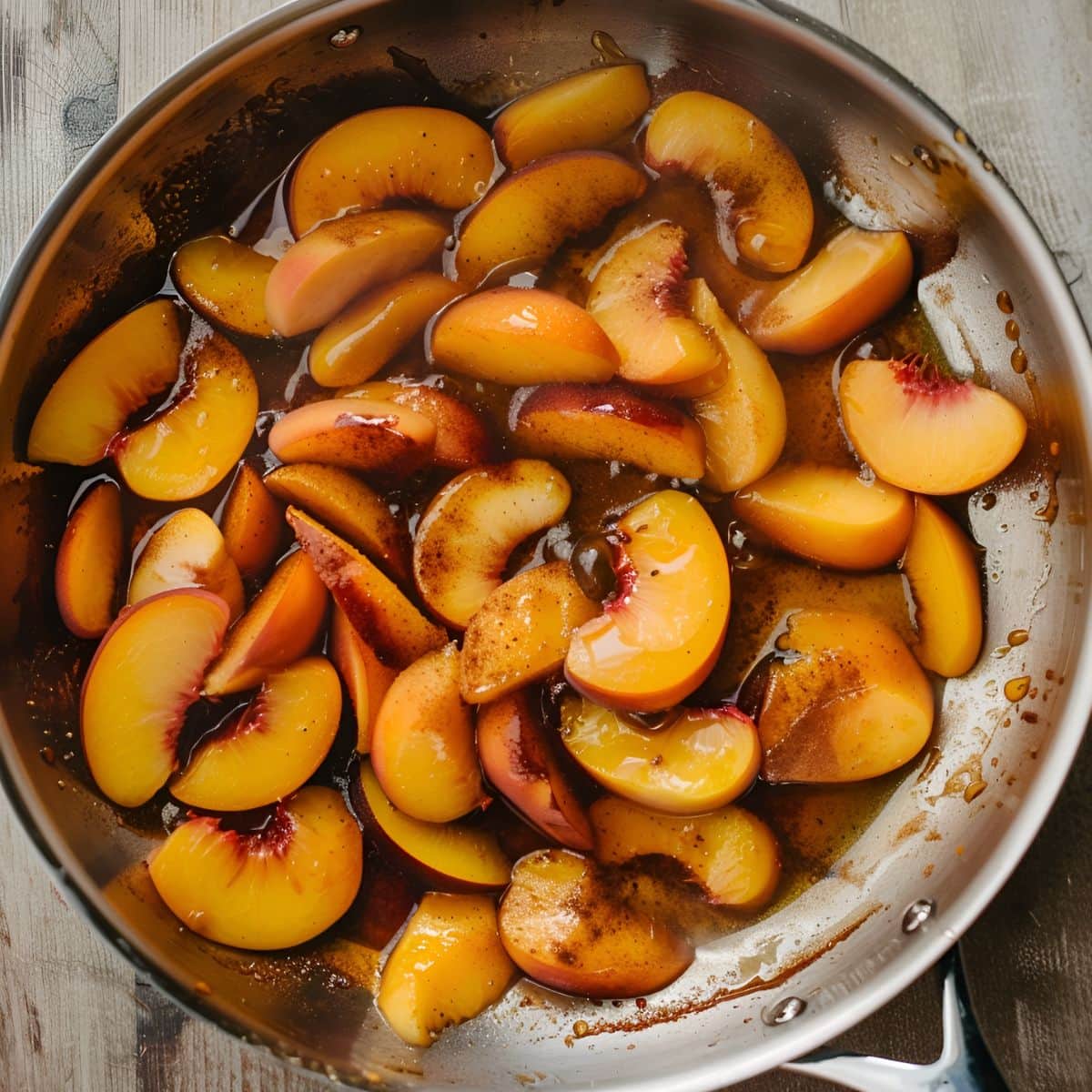 Top View of Fresh Peaches Cooking in a Frying Pan Agave Syrup and Spices