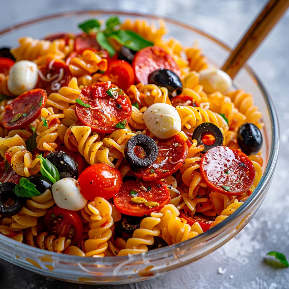 Large glass bowl with pepperoni pasta salad. 