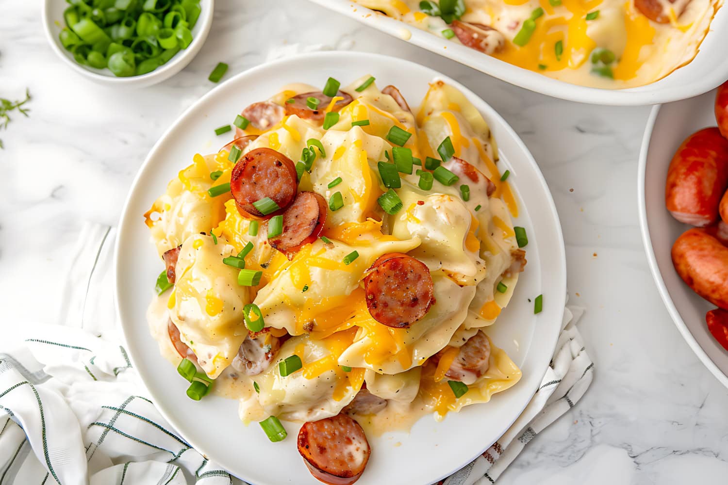 Pierogi casserole with sliced kielbesa sausage and melted cheese served in a white plate.
