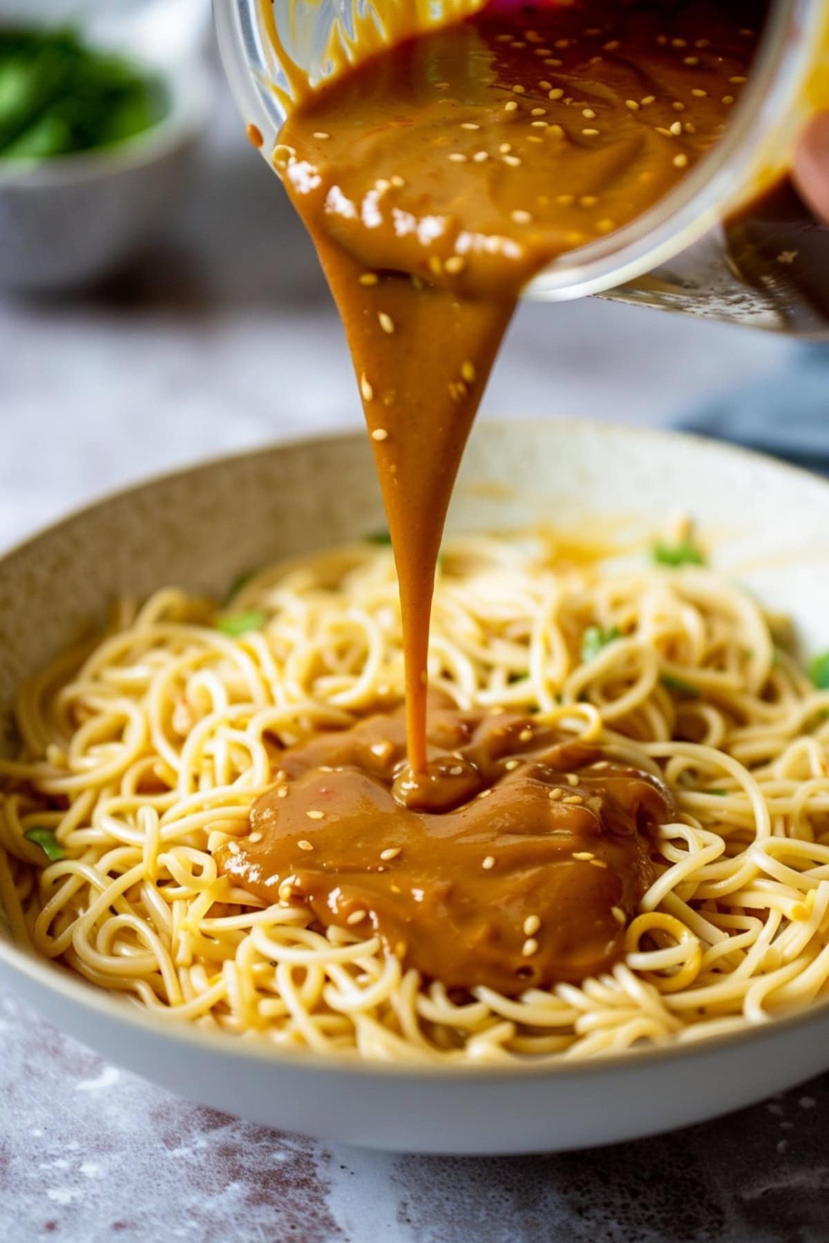 Homemade noodles featuring a peanut sauce poured into it.