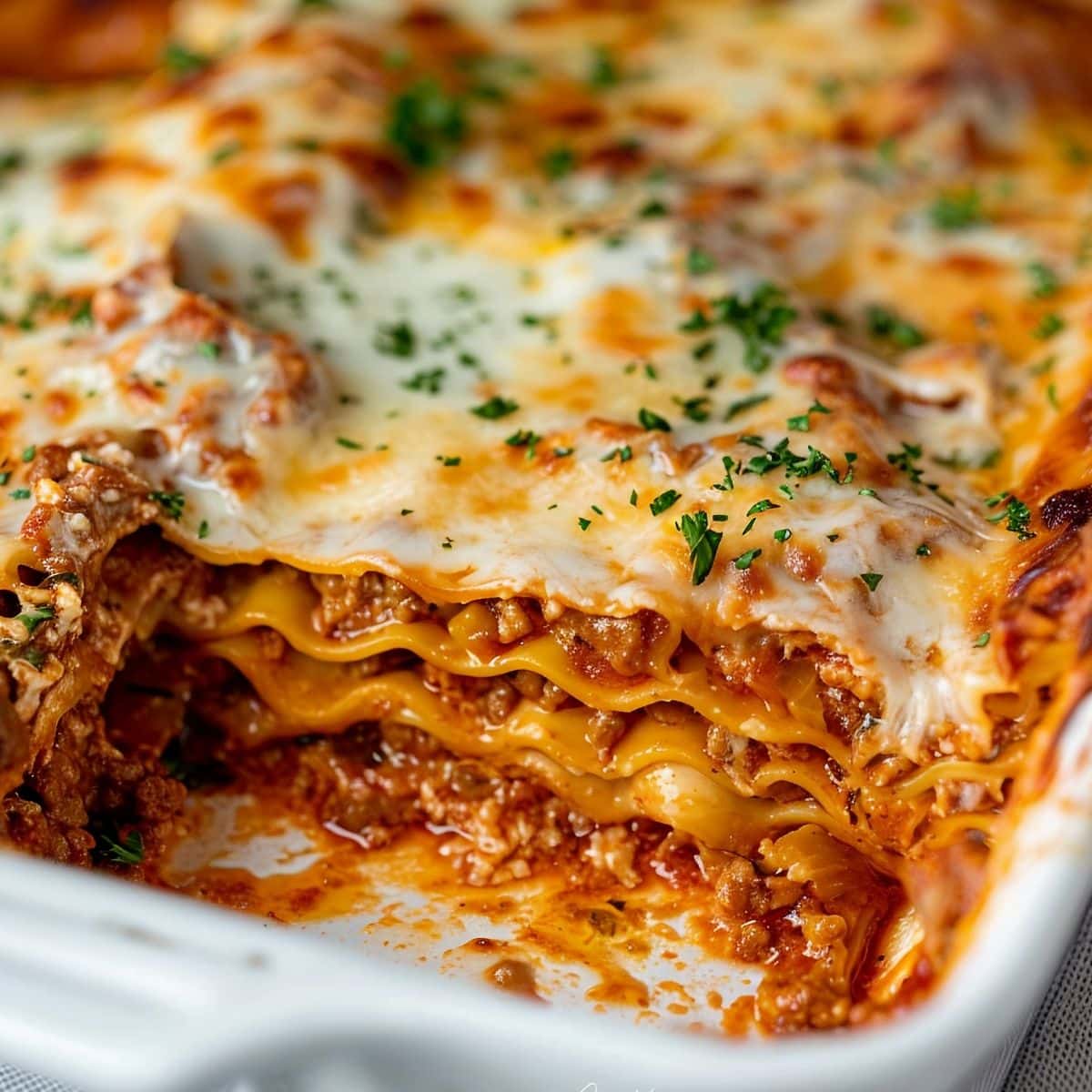 Close Up of Prego Lasagna in a White Baking Dish with a Piece Missing