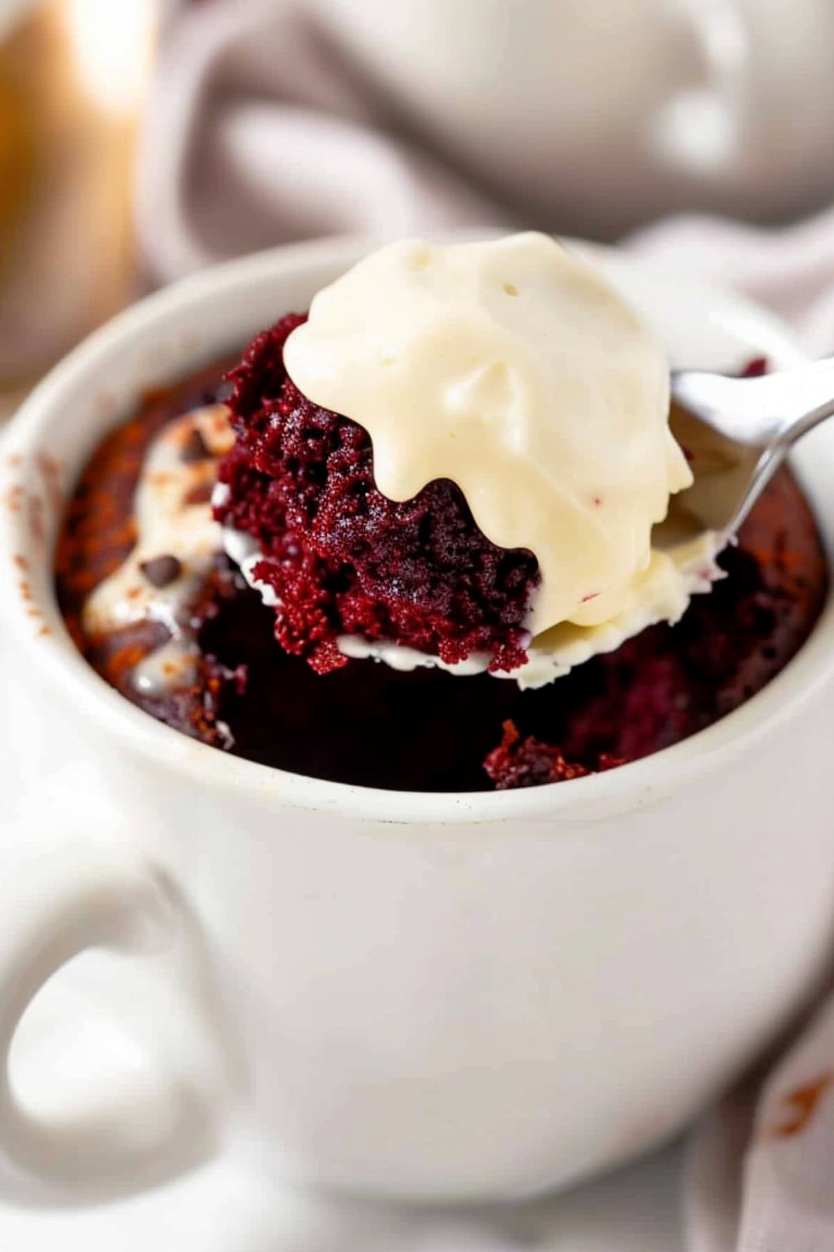 Moist and fluffy red velvet mug cake with tangy cream cheese frosting.