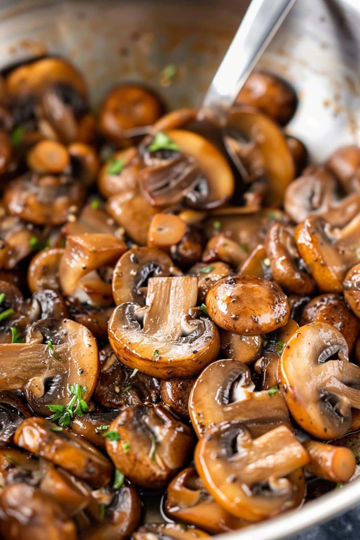 A close-up shot of sliced variety of mushrooms in a saucepan. 