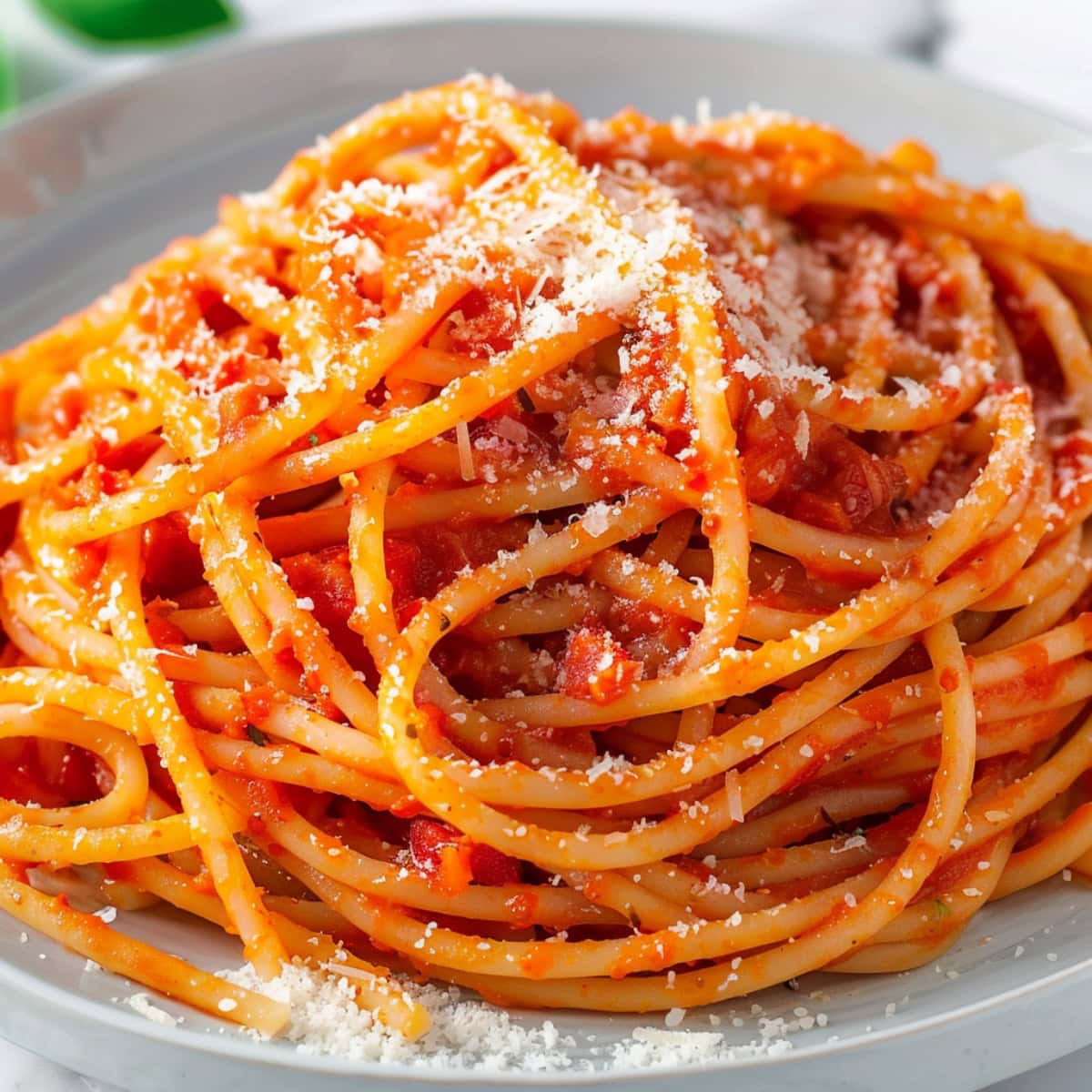 Fresh pasta pomodoro, garnished with basil and parmesan cheese.