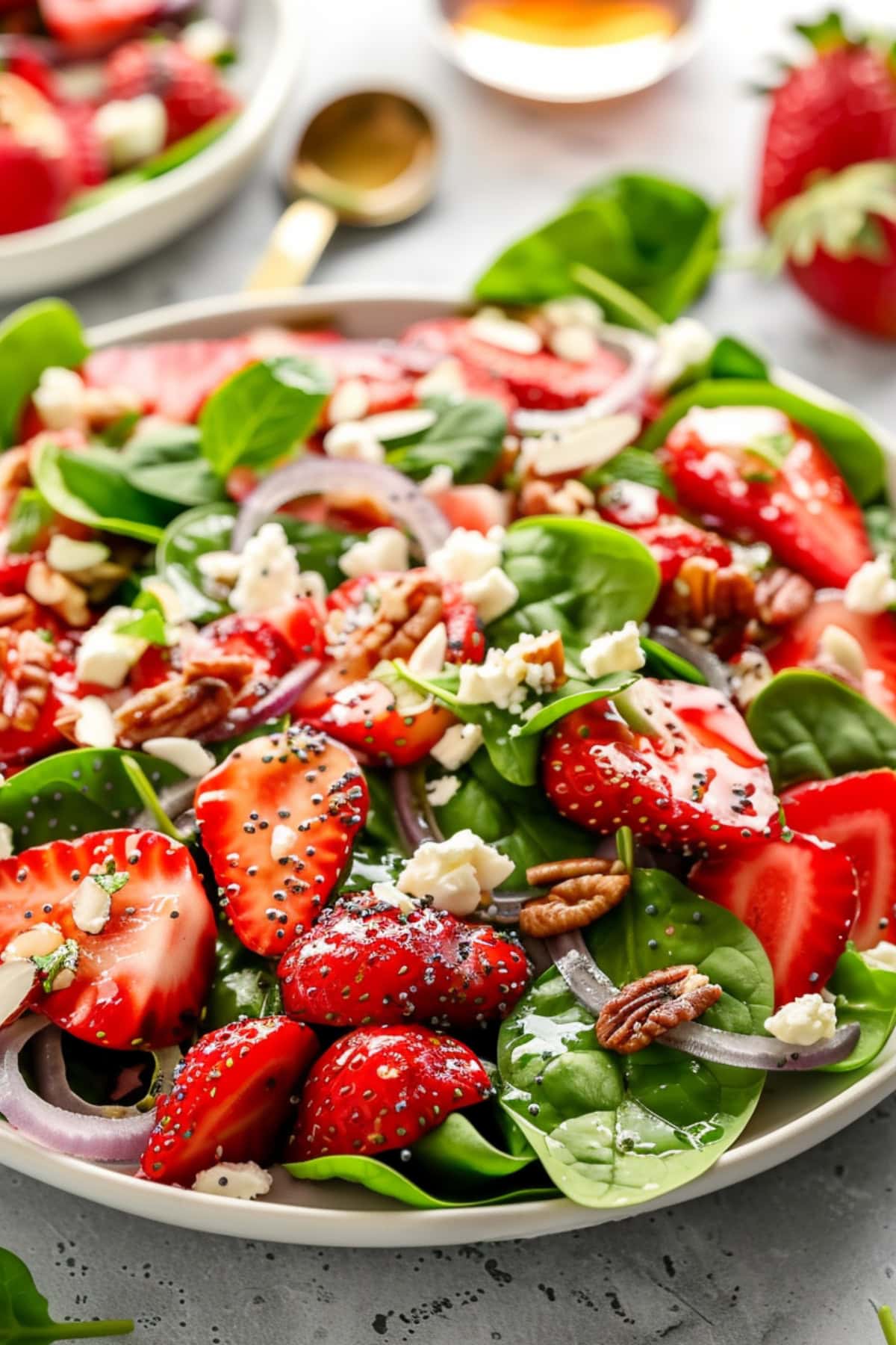 Spinach Strawberry Salad with Poppy Seed Dressing served in a white plate.