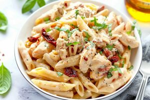 Pasta with sun-dried tomatoes with creamy sauce on a plate.