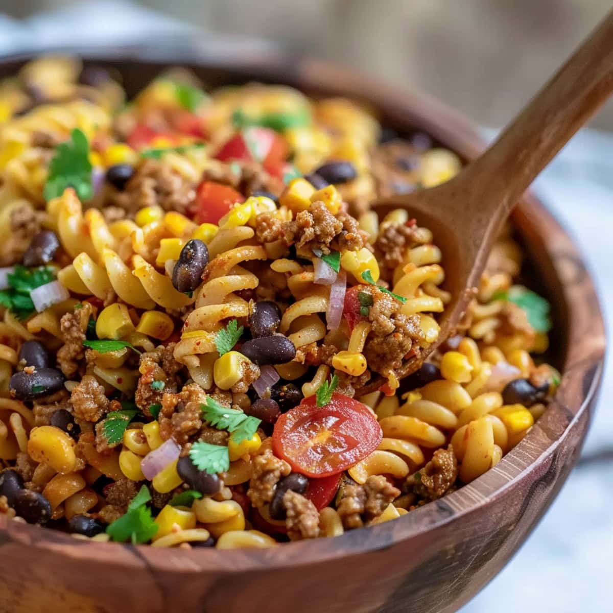 Quick and easy taco pasta salad, made with rotini, ground beef, tomatoes and corn kernels.