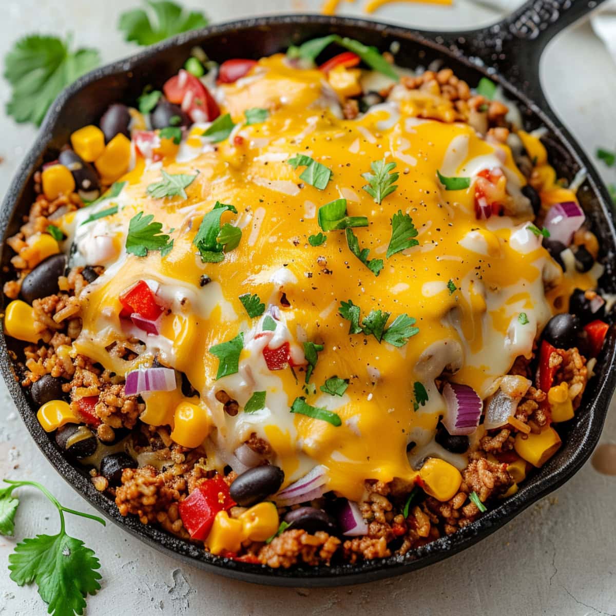 Taco skillet in a cast iron pan topped with melted cheese.