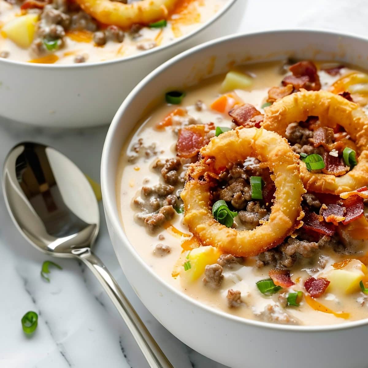 Two Bowls of Cheeseburger Soup, Topped with Onion Rings