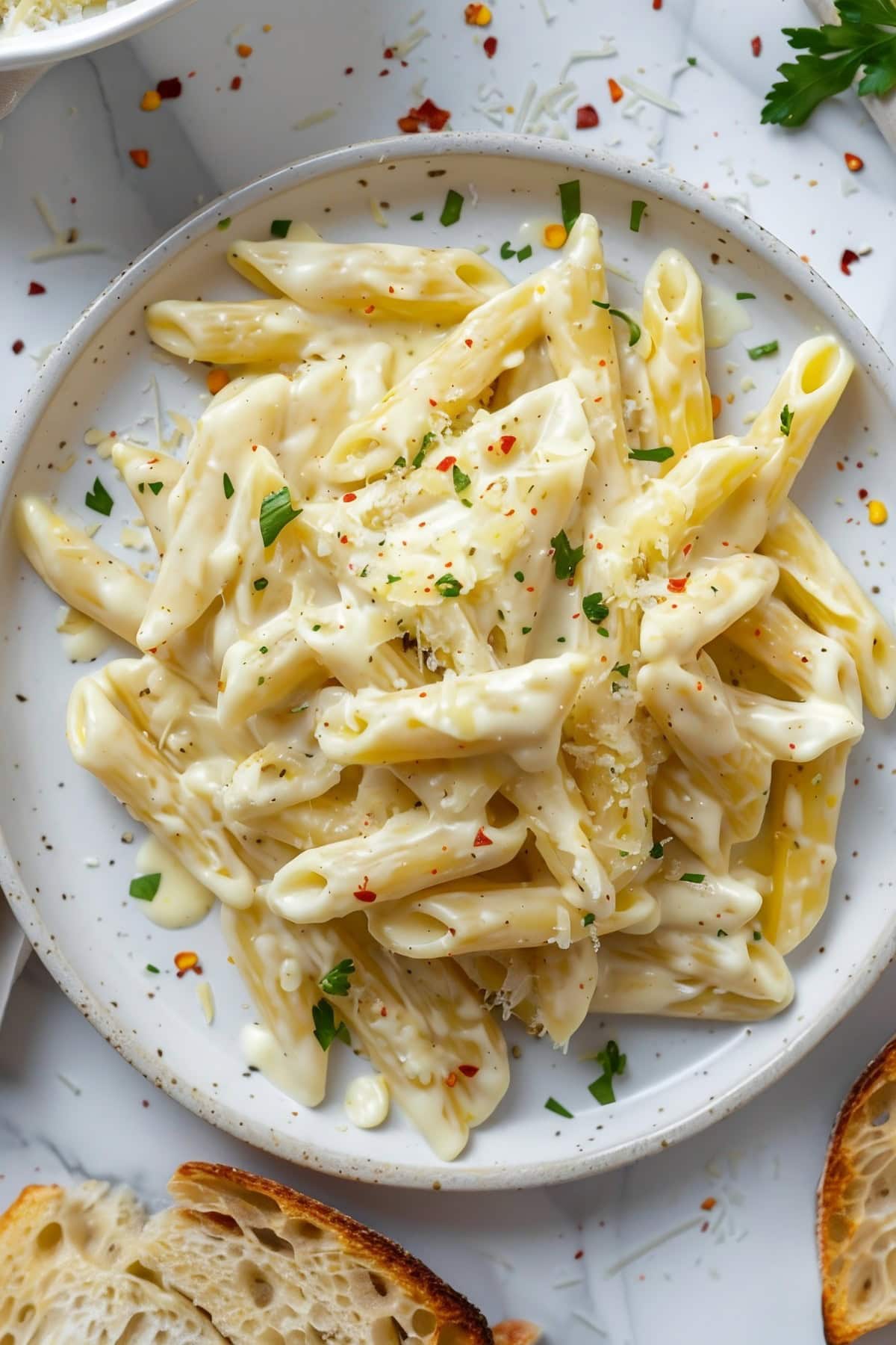 Cream Cheese Pasta serving on a white plate sprinkled with parmesan cheese.