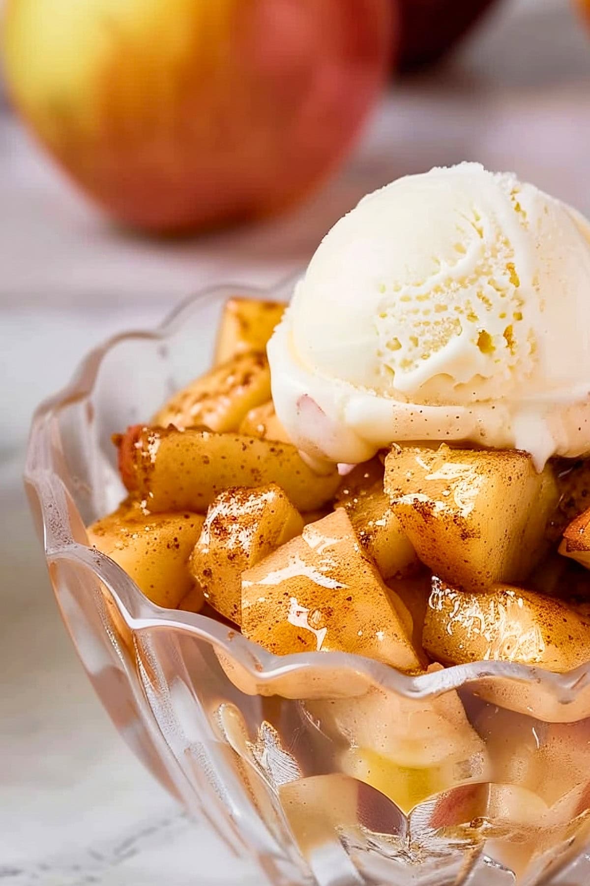 Super Close Up of Microwave Baked Apples with Cinnamon in a Glass Dish with a Scoop of Melty Vanilla Ice Cream