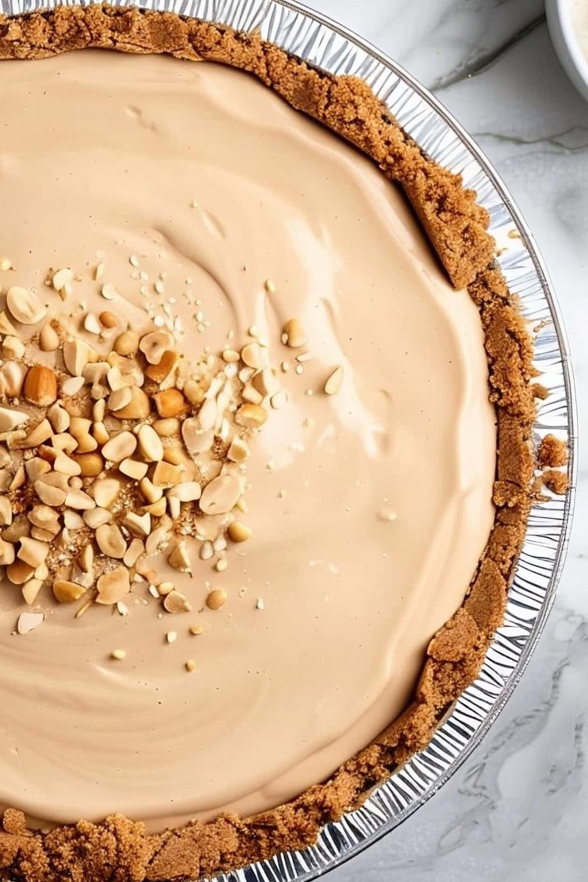 Close Up Top View of Peanut Butter Cream Pie in the Pie Tin with Crushed Peanuts on Top