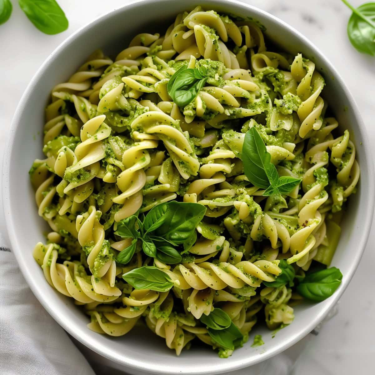 Top View of a Bowl of Pesto Pasta with Fresh Basil Leaves for Garnish